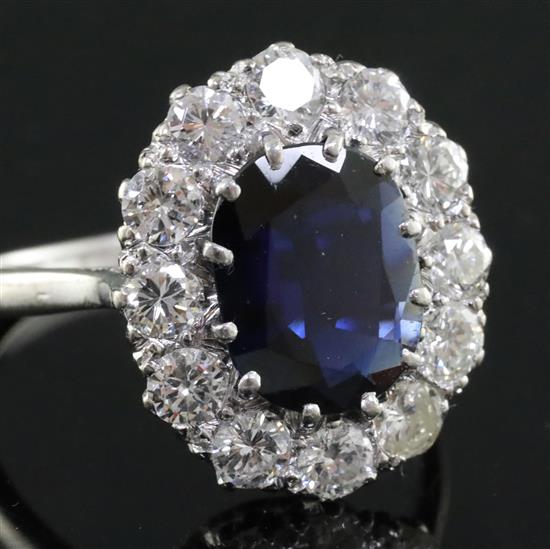 A modern white gold?, sapphire and diamond set oval cluster ring, size N.